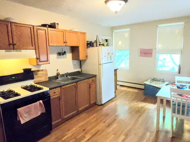 a kitchen with a refrigerator and a stove top oven