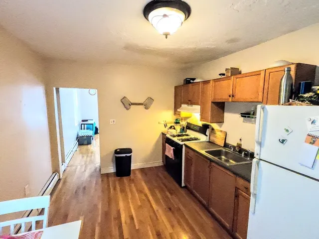 a kitchen with stainless steel appliances a stove a refrigerator a sink dishwasher and wooden cabinets