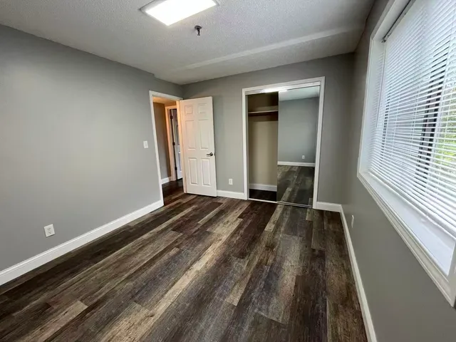 a view of a room with wooden floor and window