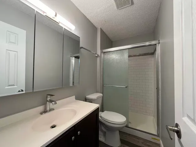 a bathroom with a sink mirror toilet and shower