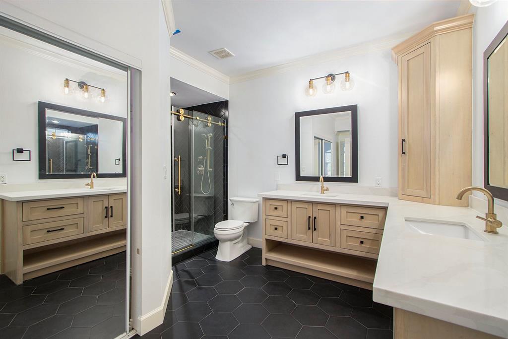a bathroom with a double vanity sink toilet and mirror