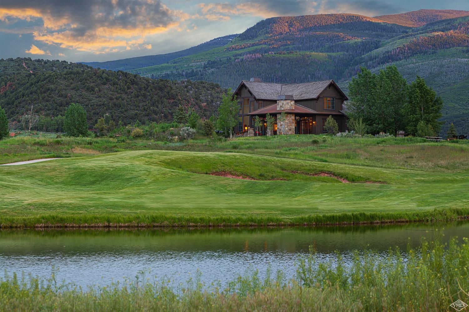 a view of a big house with a big yard and a large mountain view