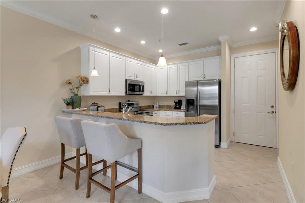 9098 Capistrano Street South, Unit 7102 Naples, FL 34113 - Photo 4 of 23 kitchen with door to the garage
