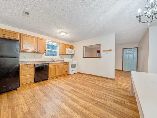 a kitchen with stainless steel appliances granite countertop a sink cabinets and wooden floor