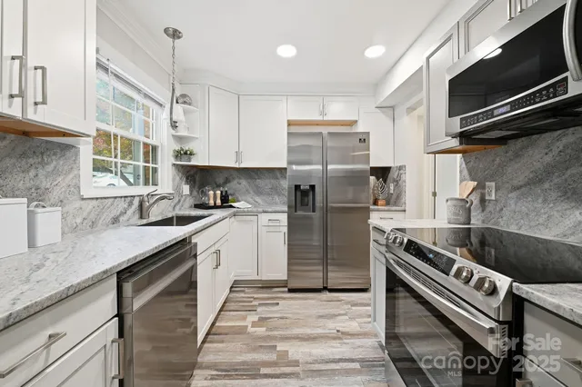 a kitchen with stainless steel appliances granite countertop a sink stove and refrigerator