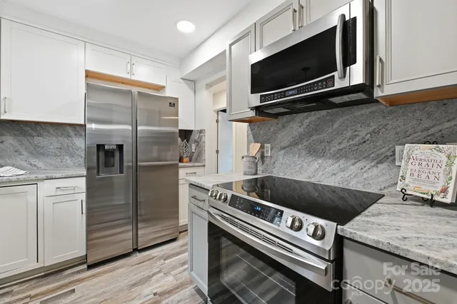 a kitchen with granite countertop a stove and a microwave