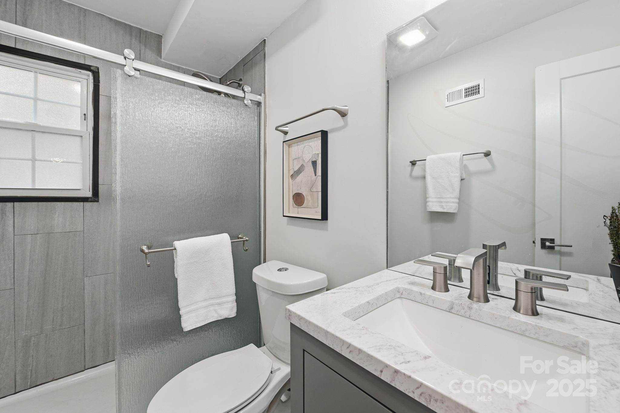 912 McAlway Road, Unit A Charlotte, NC 28211 - Photo 21 of 33 a bathroom with a granite countertop toilet sink and mirror