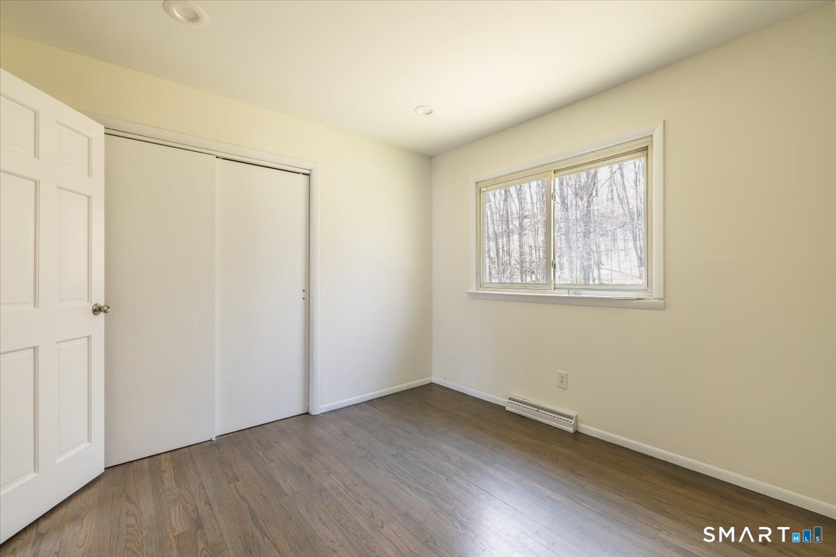 370 Quaker Farms Road Southbury, CT 06488 - Photo 13 of 35 an empty room with wooden floor and windows
