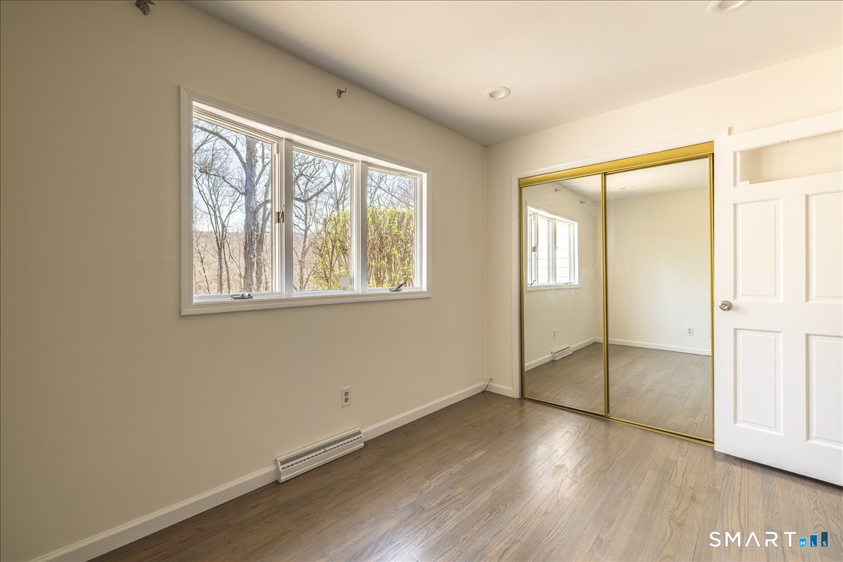 370 Quaker Farms Road Southbury, CT 06488 - Photo 14 of 35 an empty room with wooden floor and windows