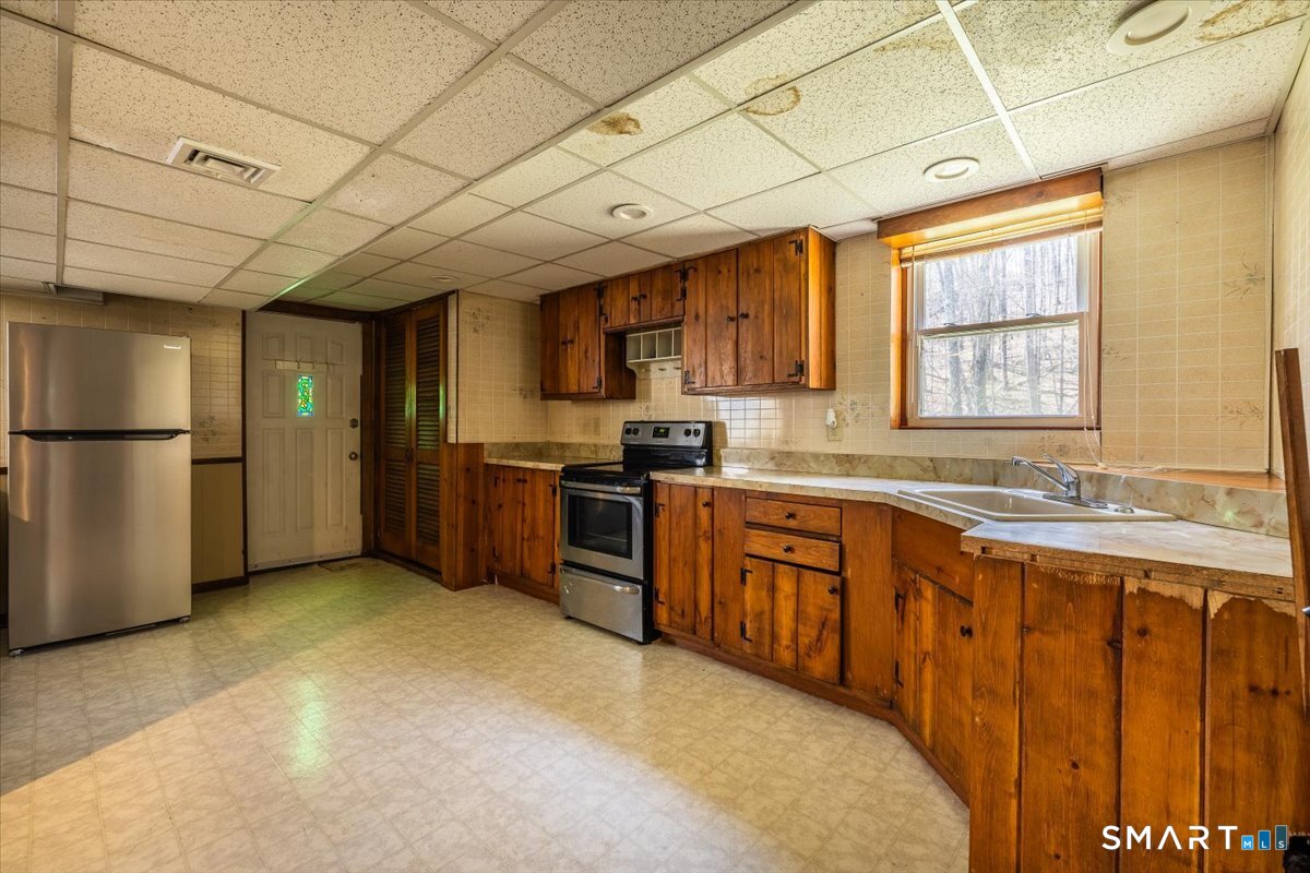 370 Quaker Farms Road Southbury, CT 06488 - Photo 28 of 35 a kitchen with stainless steel appliances granite countertop a sink a stove a refrigerator cabinets and a dining table