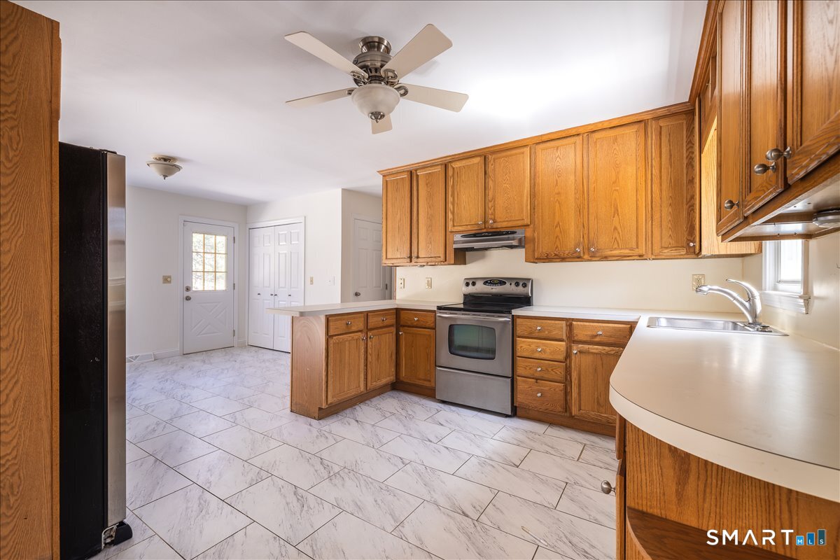 370 Quaker Farms Road Southbury, CT 06488 - Photo 8 of 35 a kitchen with a sink a stove cabinets and a counter top space