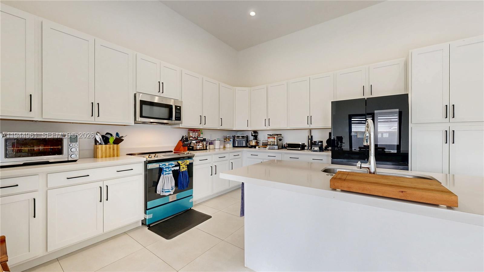 31171 Southwest 193rd Avenue Homestead, FL 33030 - Photo 11 of 36 a kitchen with stainless steel appliances granite countertop a refrigerator a stove top oven a sink dishwasher and white cabinets