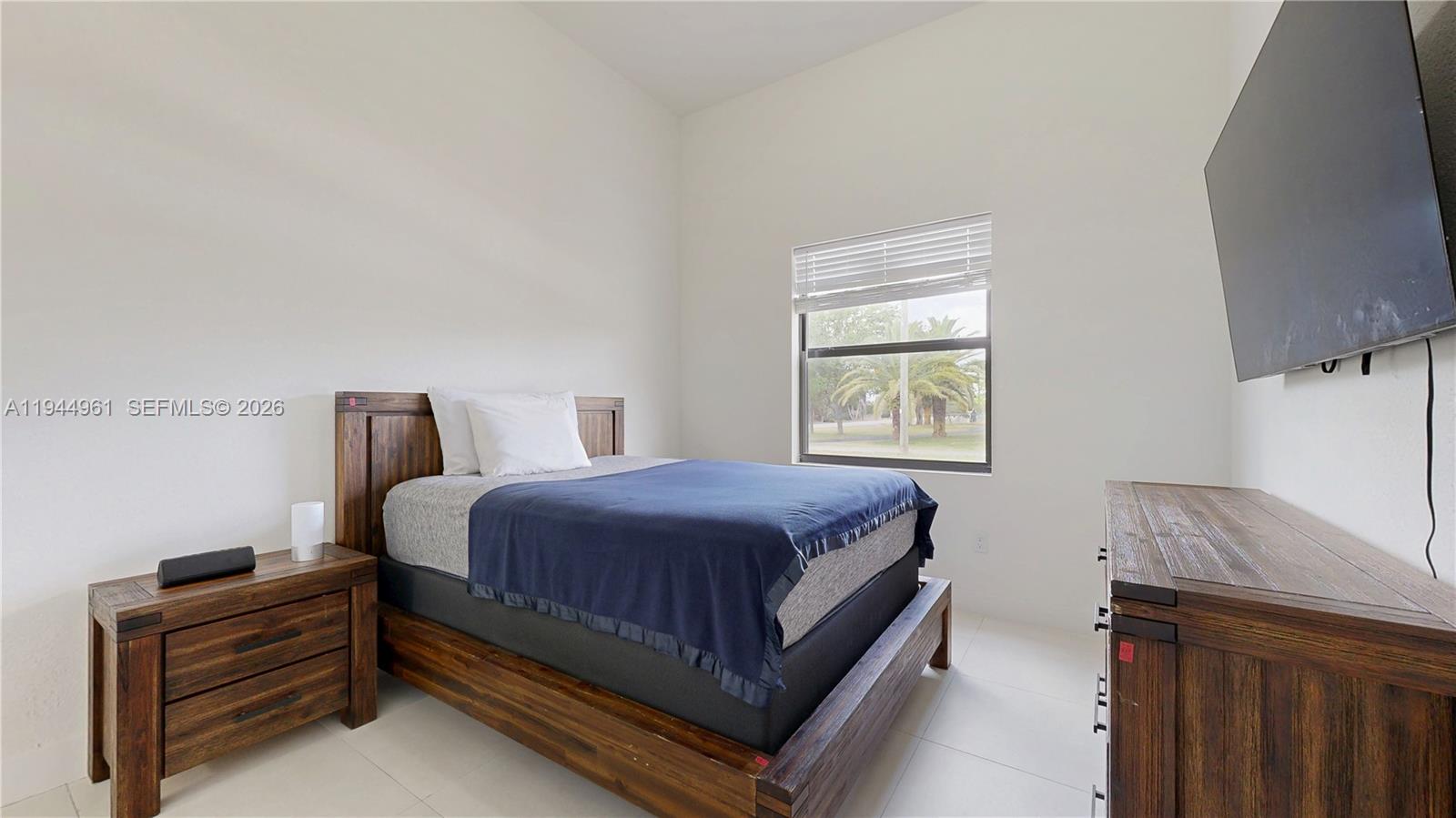 31171 Southwest 193rd Avenue Homestead, FL 33030 - Photo 18 of 36 a bedroom with a bed and a flat tv screen on a dresser
