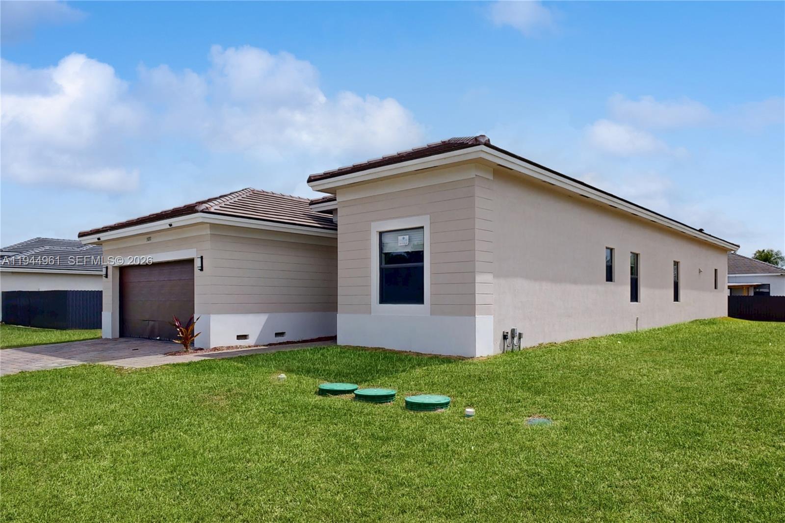 31171 Southwest 193rd Avenue Homestead, FL 33030 - Photo 5 of 36 a front view of house with yard and garage