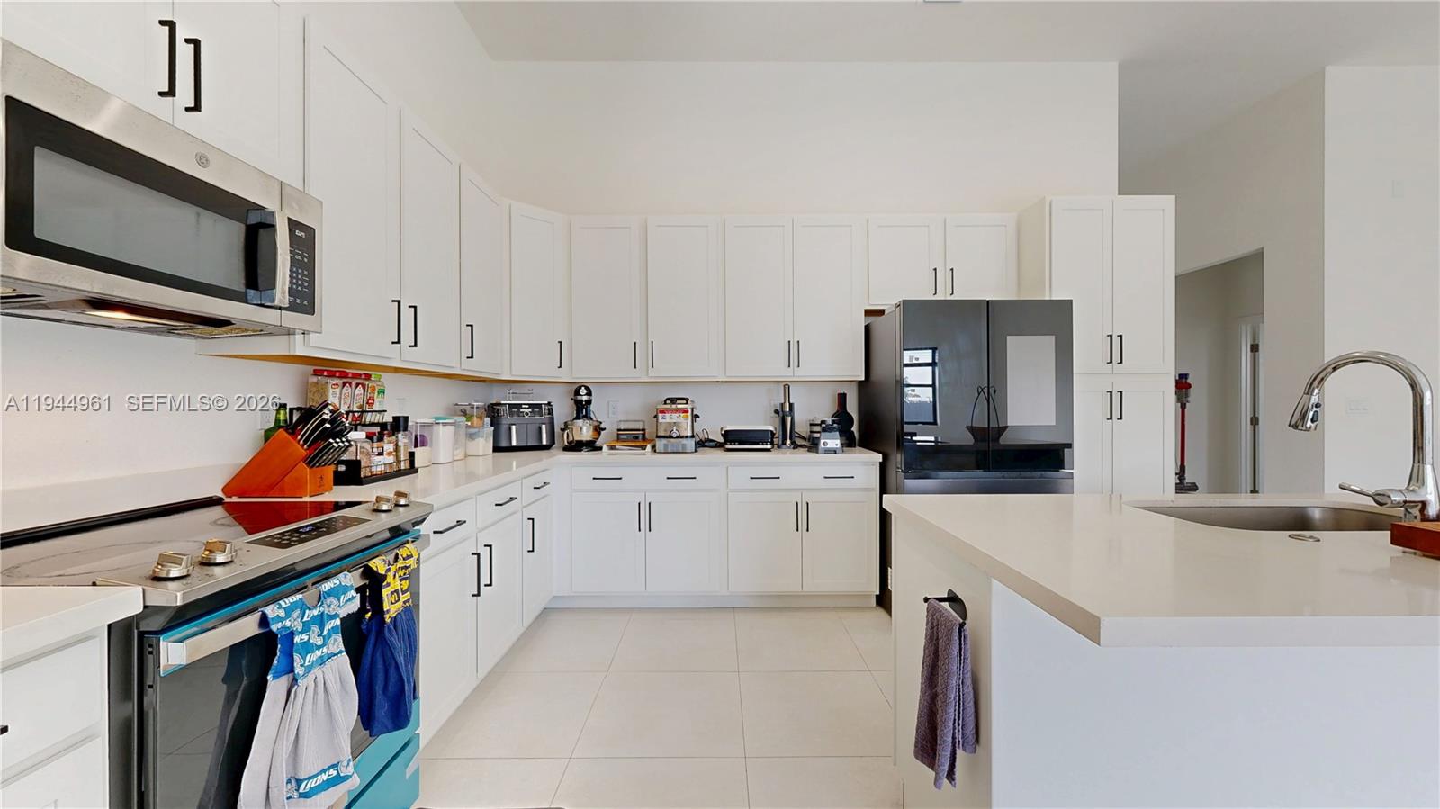 31171 Southwest 193rd Avenue Homestead, FL 33030 - Photo 10 of 36 a kitchen with stainless steel appliances granite countertop a sink dishwasher stove and white cabinets with wooden floor