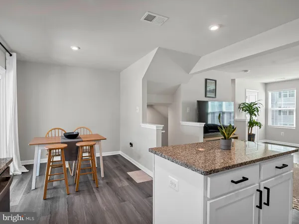 a kitchen with granite countertop kitchen island a table and chairs in it