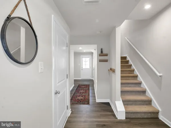 a view of a hallway with wooden floor and entryway
