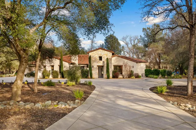 a front view of a house with a yard and trees