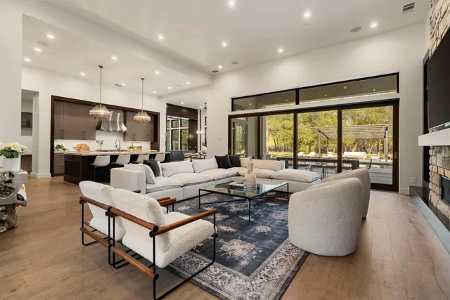 a living room with furniture a flat screen tv and kitchen view