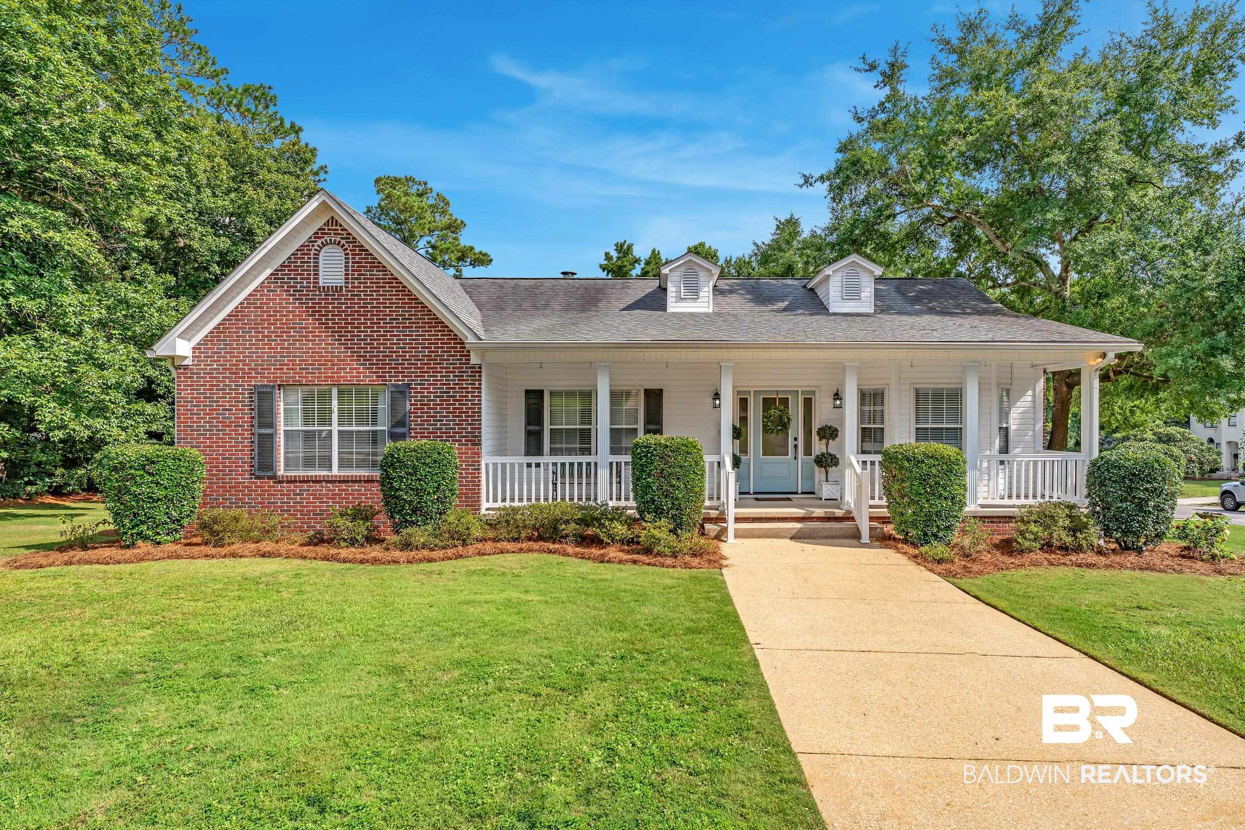 2 Navy Lane Daphne, AL 36527 - Photo 2 of 28 View of front facade featuring a porch, a front yard, brick siding, and roof with shingles