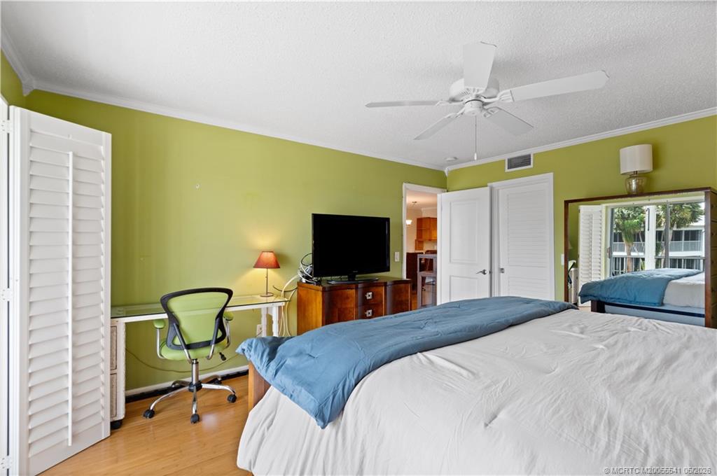 1866 Southwest Palm City Road, Unit 204 Stuart, FL 34994 - Photo 21 of 38 a bedroom with a bed and a flat screen tv