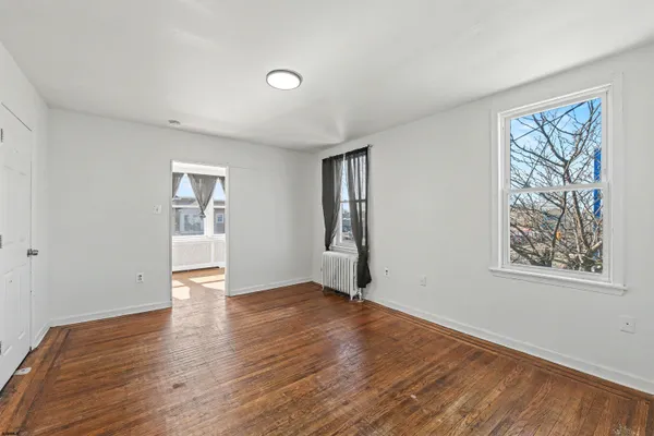 a view of an empty room with wooden floor
