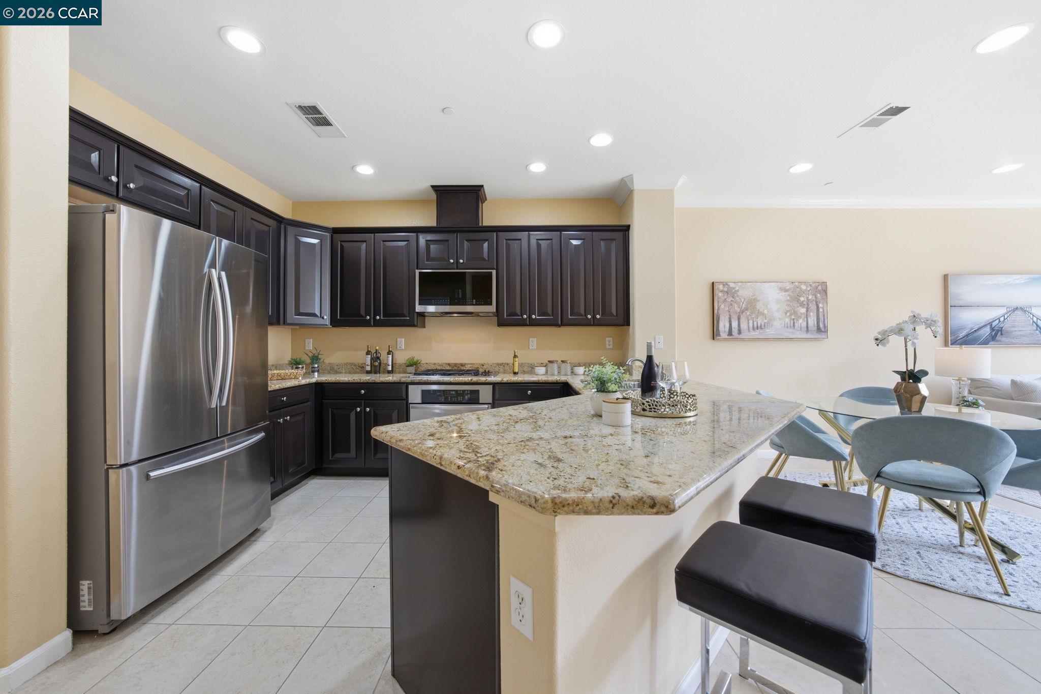 252 Sullivan Way Hayward, CA 94541 - Photo 18 of 55 a kitchen with kitchen island granite countertop a sink refrigerator and cabinets