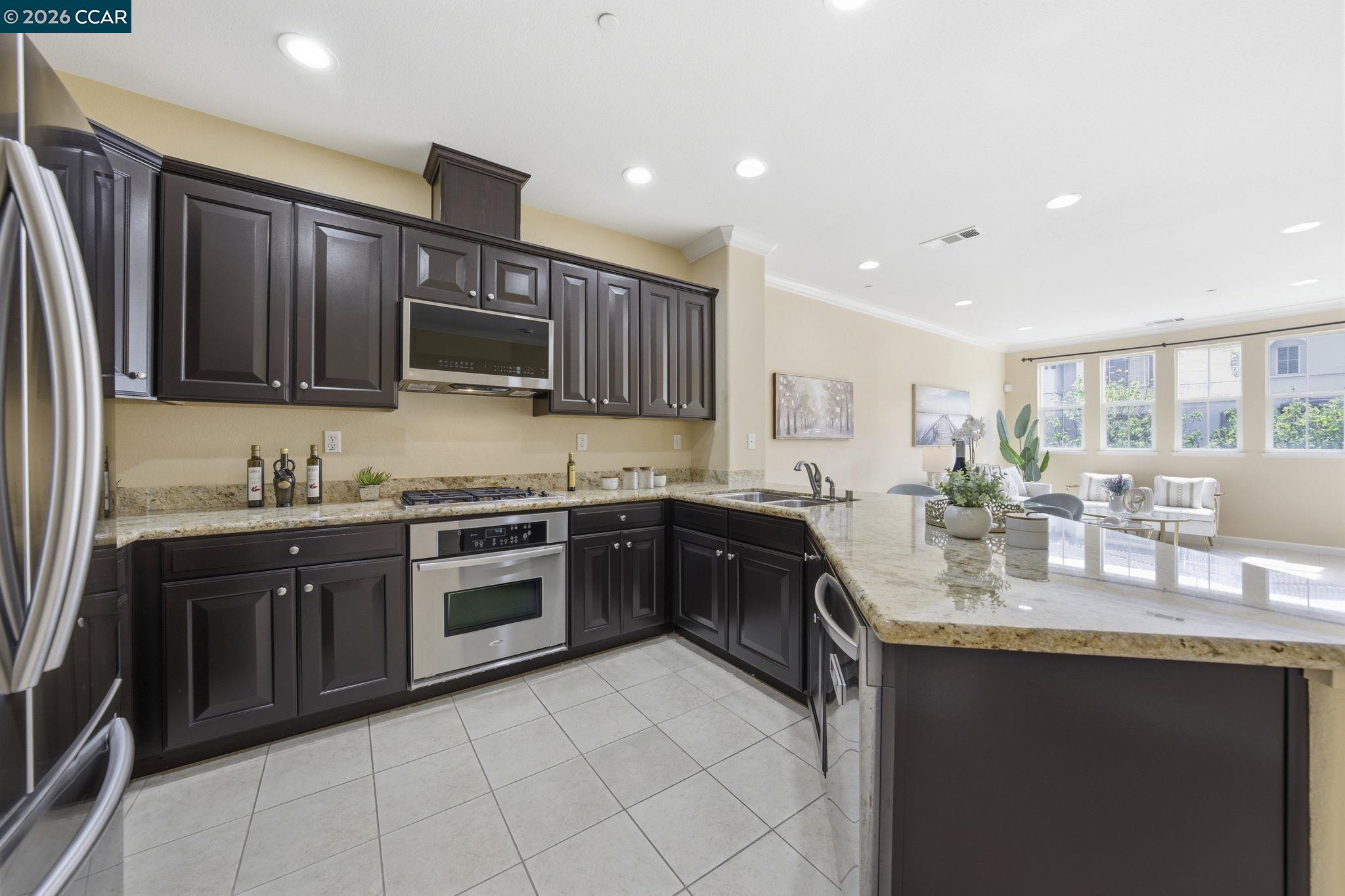 252 Sullivan Way Hayward, CA 94541 - Photo 20 of 55 a large kitchen with granite countertop a stove top oven a sink dishwasher and wooden cabinets with granite countertops