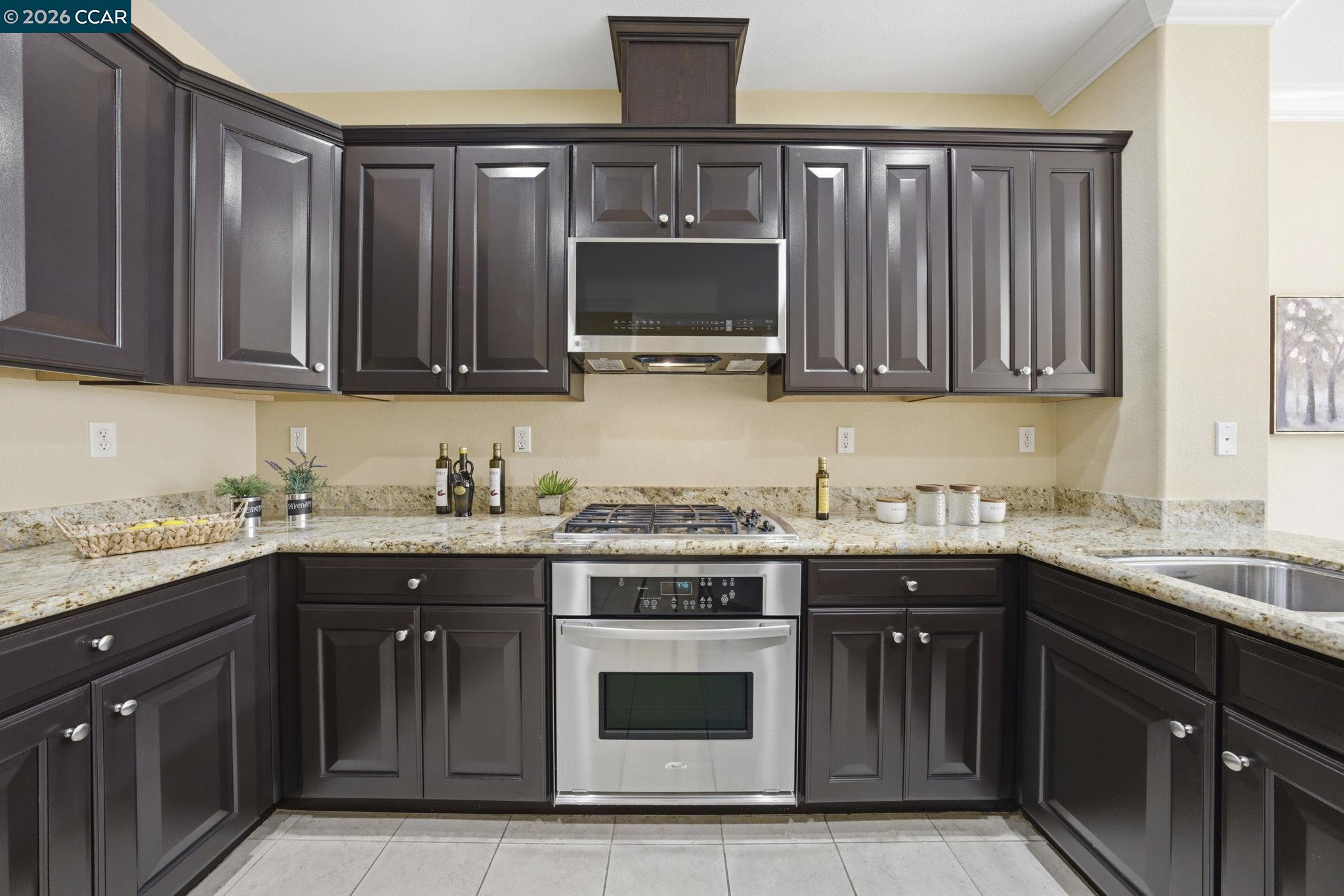 252 Sullivan Way Hayward, CA 94541 - Photo 22 of 55 a kitchen with stainless steel appliances granite countertop a stove a sink and a microwave