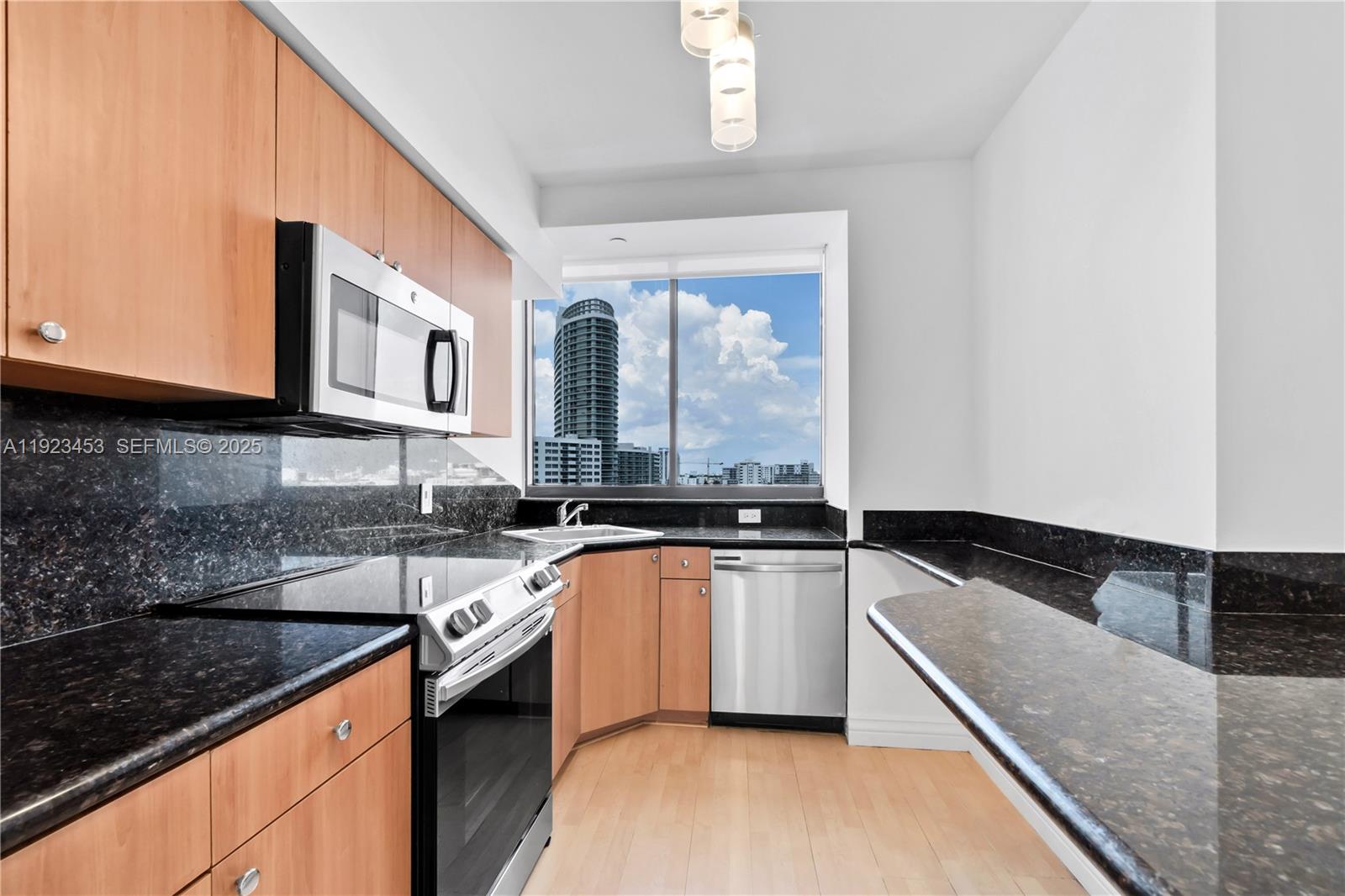 1330 West Avenue, Unit 1009 Miami Beach, FL 33139 - Photo 13 of 43 a kitchen with granite countertop a sink and a stove top oven
