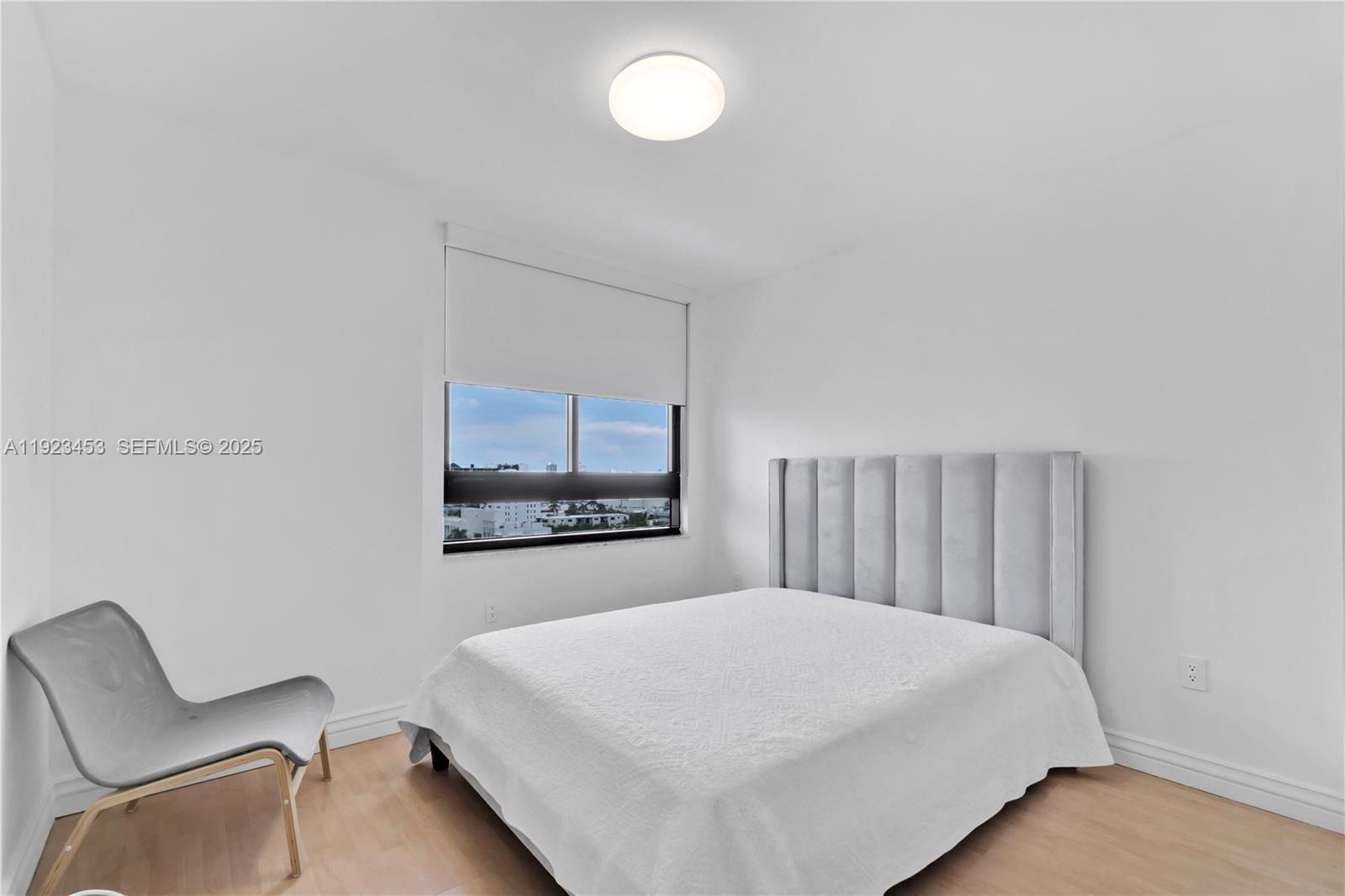1330 West Avenue, Unit 1009 Miami Beach, FL 33139 - Photo 15 of 43 a bedroom with a bed and a chair