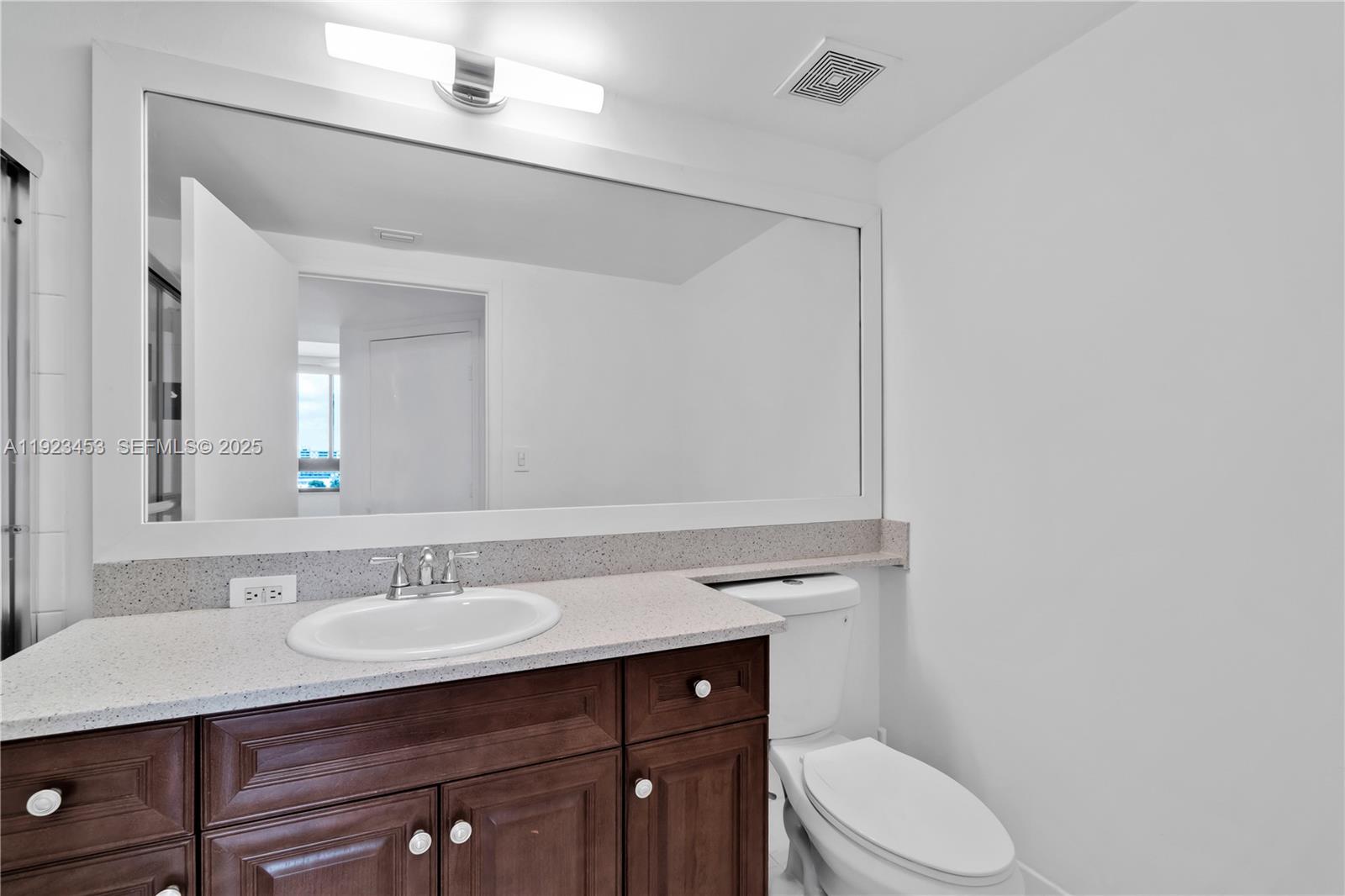1330 West Avenue, Unit 1009 Miami Beach, FL 33139 - Photo 23 of 43 a bathroom with a sink vanity mirror and toilet