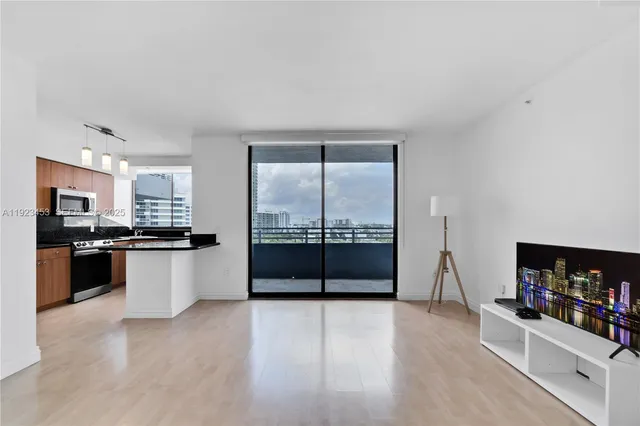 a kitchen with stainless steel appliances wooden floor and a refrigerator