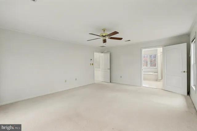 a view of an empty room with a ceiling fan