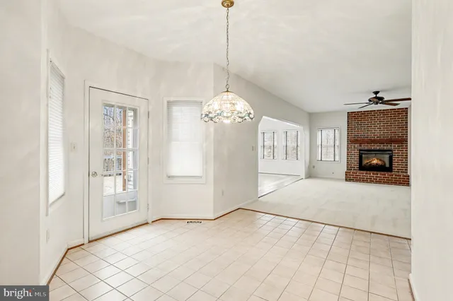 a view of empty room with fireplace and chandelier
