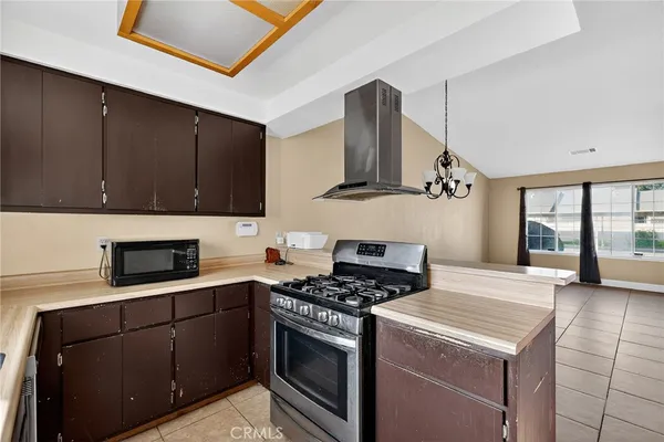 a kitchen with granite countertop a sink a stove and cabinets
