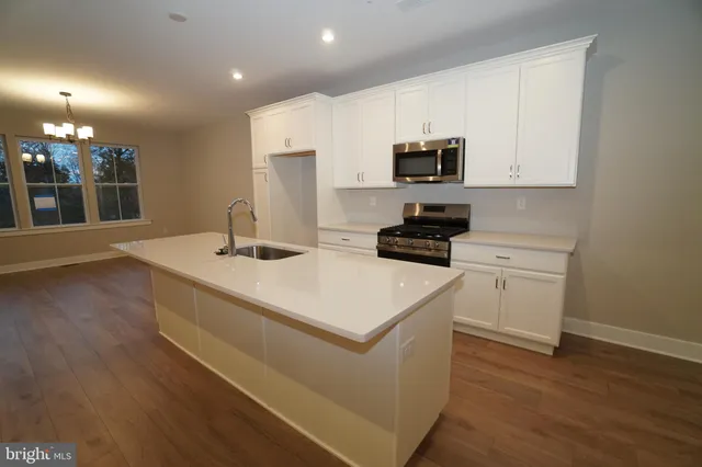 a kitchen with a sink a stove and cabinets