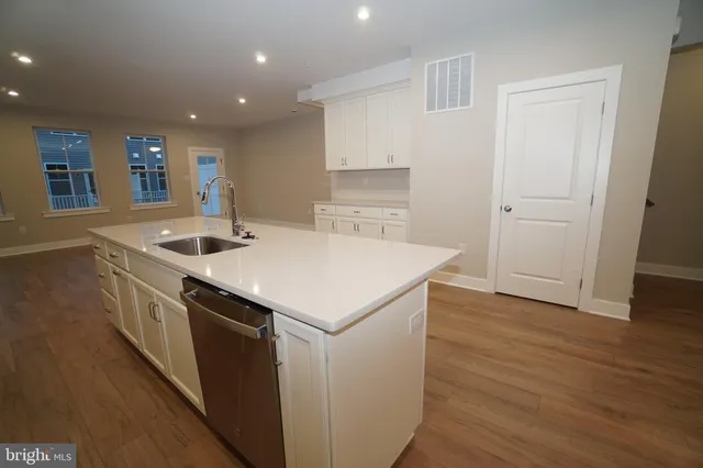 a kitchen that has a sink and a microwave oven on counter top