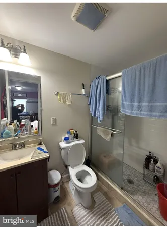 a bathroom with a toilet sink a mirror and shower