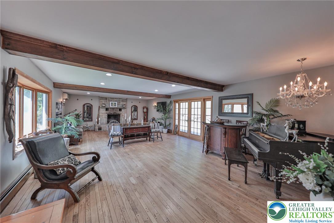 4985 Church View Road Zionsville, PA 18092 - Photo 2 of 7 Exposed beams and a stone fireplace create a rustic yet elegant gathering space.