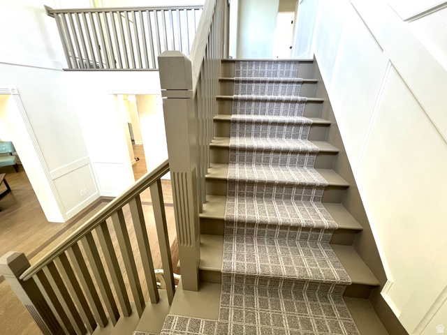 812 East Bates Cyn Road Tooele, UT 84074 - Photo 53 of 144 Staircase with patterned runner, painted balusters, and a paneled wall