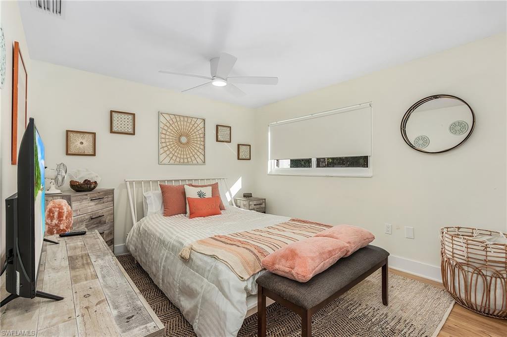 2950 Coach House Lane Naples, FL 34105 - Photo 14 of 50 a bedroom with a large bed and a chandelier