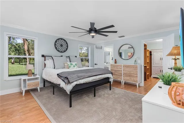 a bedroom with a bed and a table in it with a large window