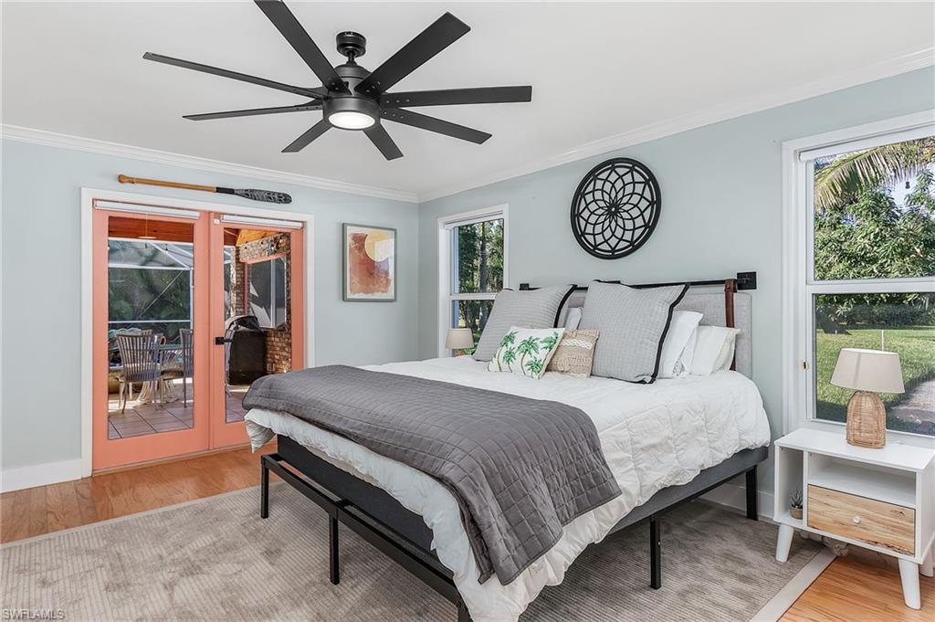 2950 Coach House Lane Naples, FL 34105 - Photo 17 of 50 a bedroom with a bed and a table in it with a large window