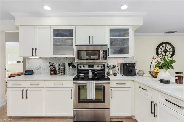 a kitchen with white cabinets and refrigerator