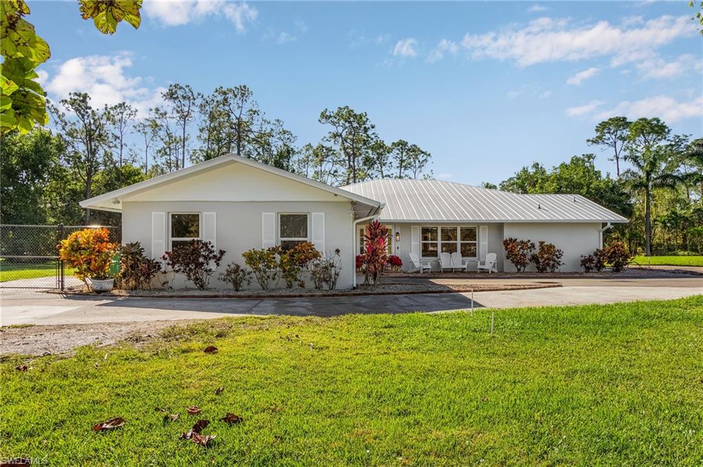 2950 Coach House Lane Naples, FL 34105 - Photo 2 of 50 a front view of a house with swimming pool having outdoor seating