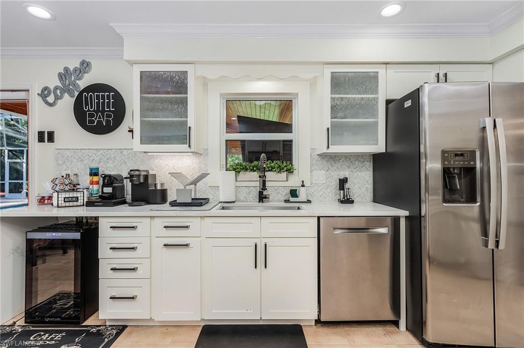 2950 Coach House Lane Naples, FL 34105 - Photo 21 of 50 a kitchen with white cabinets and refrigerator