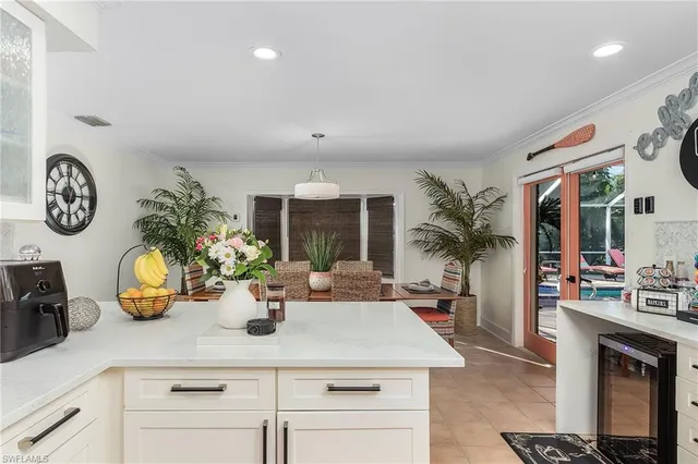 a kitchen with a sink a refrigerator and chairs