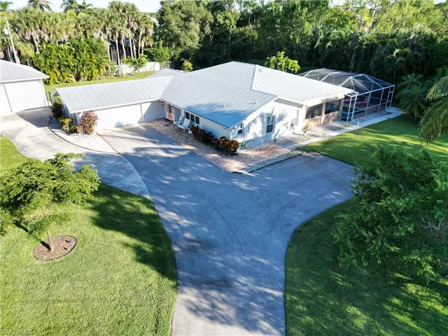 an aerial view of a house with a yard and lake
