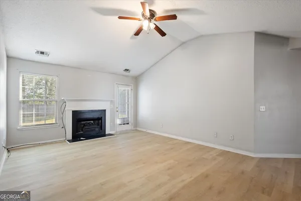 an empty room with fireplace and fan